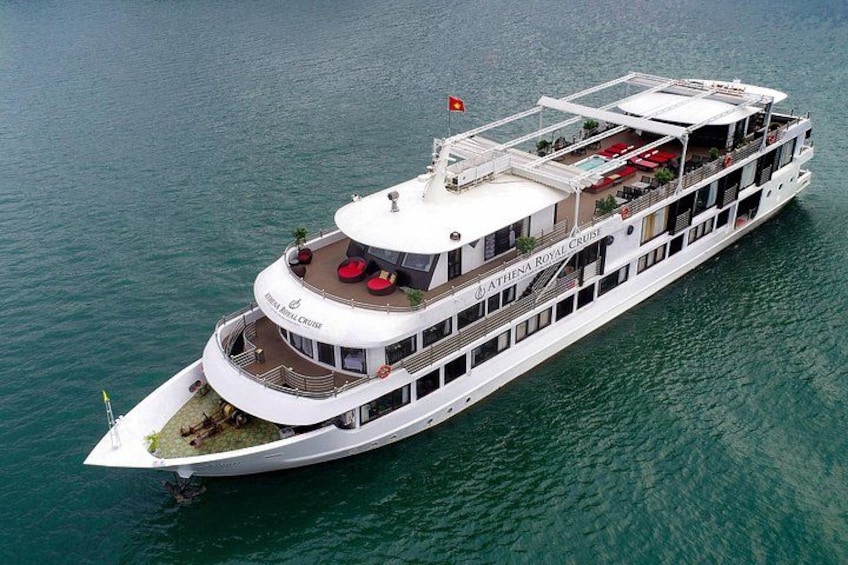 A large white cruise ship with multiple decks and outdoor seating areas. 1