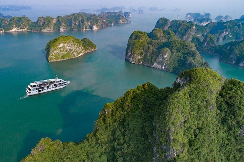 A boat on a turquoise sea surrounded by lush green islands. 2