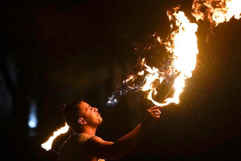 A person performing a fire-breathing act with flames. 4