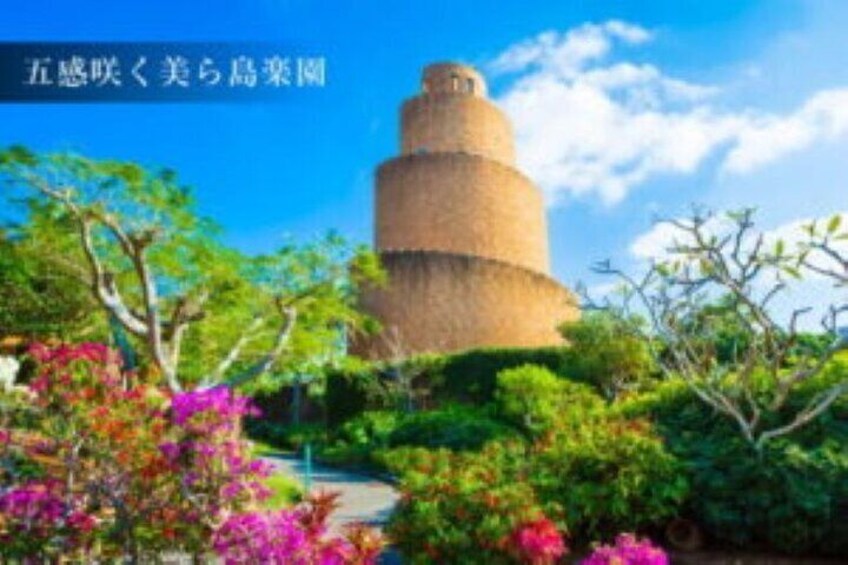 Una torre histórica rodeada de exuberante vegetación y coloridas flores. 1