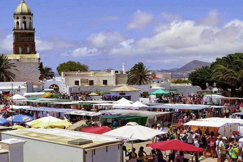 A bustling outdoor market with tents and people. 2