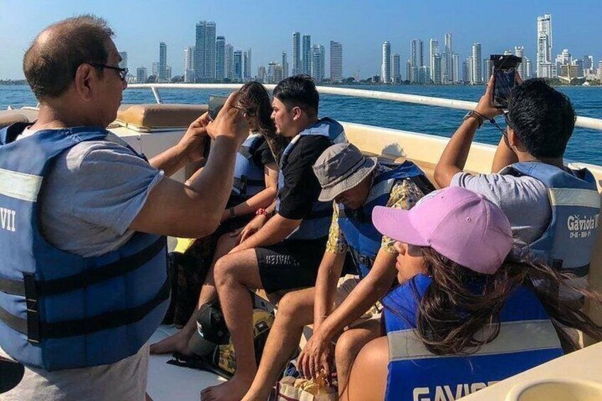 Un grupo de personas en un barco, con un horizonte urbano de fondo. 5