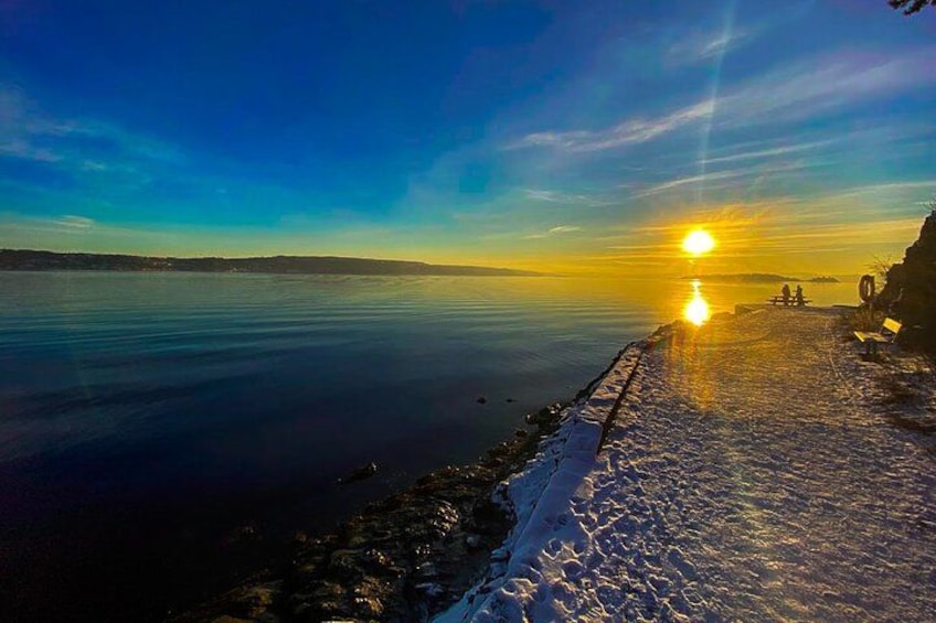 A sunset over a calm lake with a wooden pier extending into the water. 3