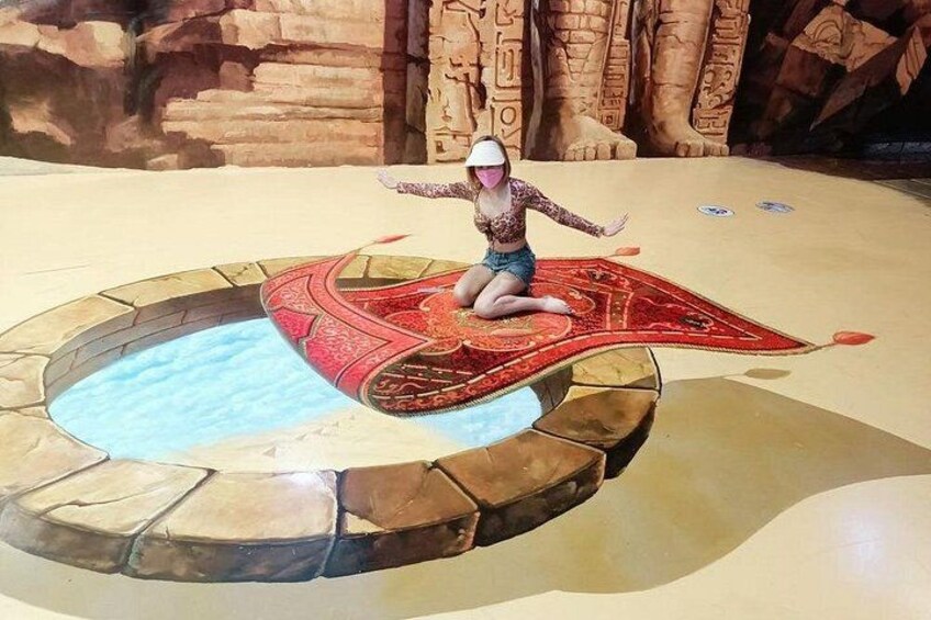 A person sitting on a red carpet in front of a stone pool. 1