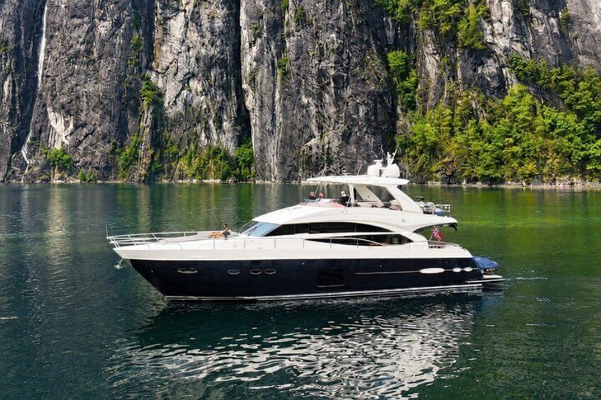 Un grande yacht su acque calme, con una scogliera rocciosa sullo sfondo. 4