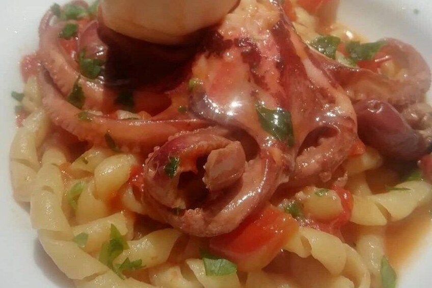 Un piatto con pasta, carne e erbe aromatiche. 4