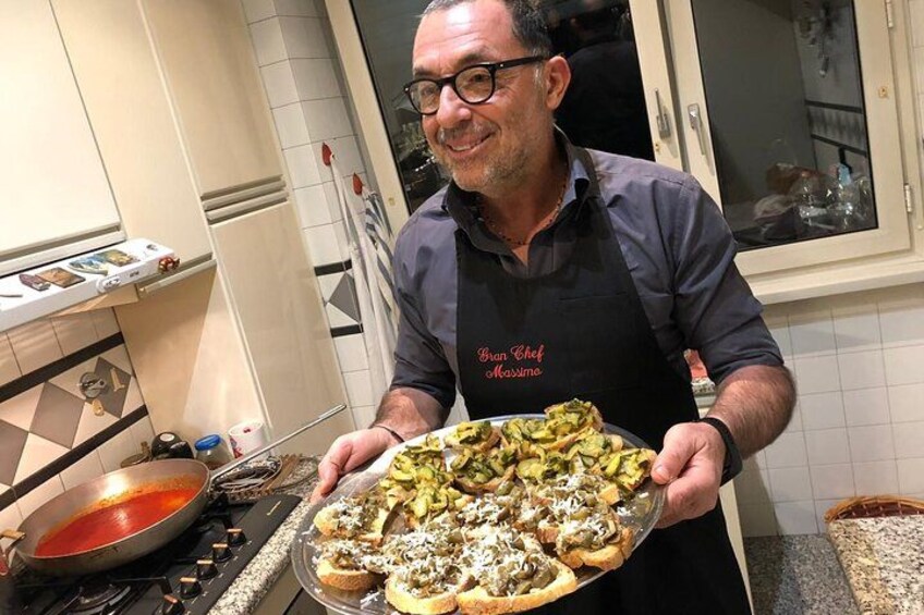A person holding a tray of food in a kitchen. 2