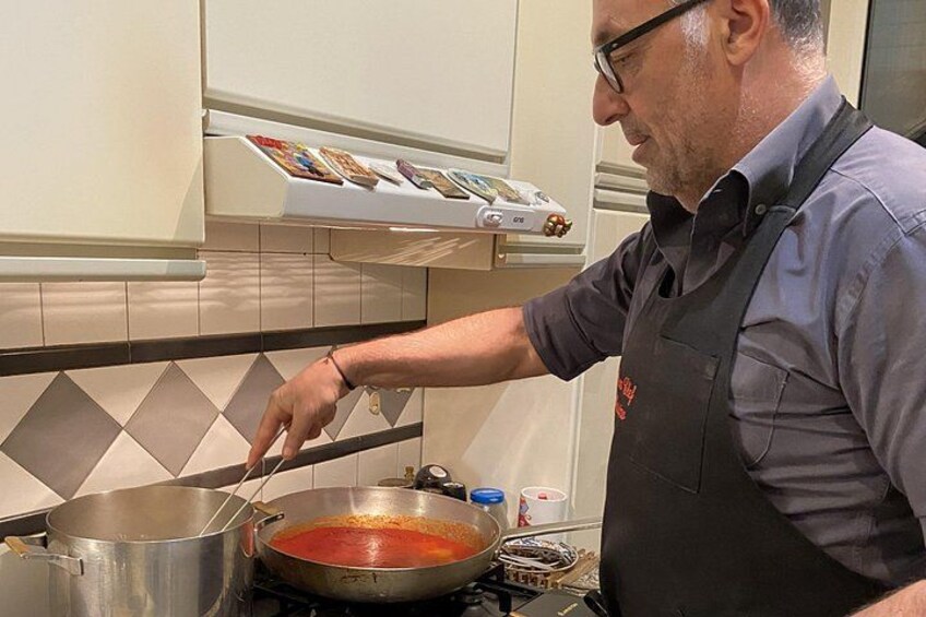 Una persona cucina in una cucina con un fornello, pentole e uno schienale piastrellato. 3