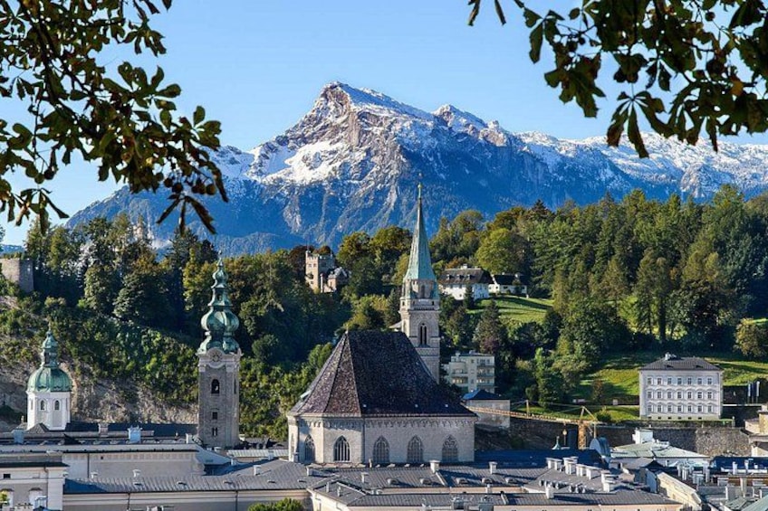 Eine Stadt mit einer markanten Kirche, einem Berg im Hintergrund und umgebender Natur. 2