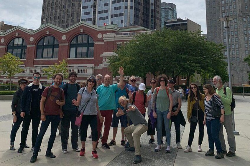 A group of people posing for a photo in an urban setting with a historic building in the background. 4