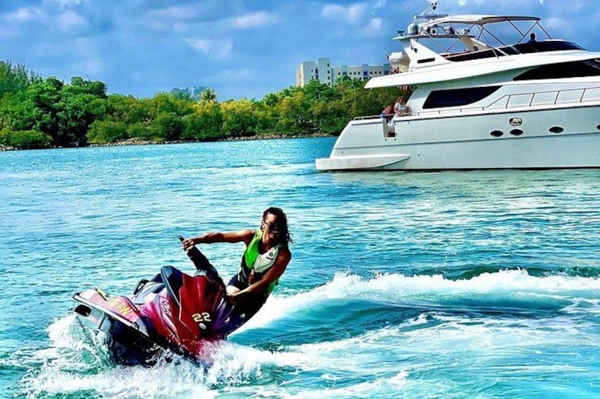 En person som åker vattenskidor på en wakeboard, en stor lyxyacht i bakgrunden och en klarblå himmel. 5