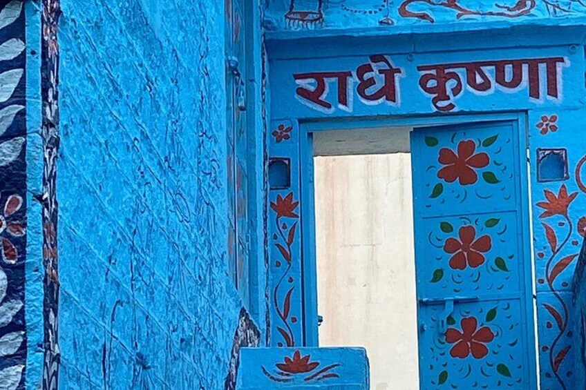 A blue door with floral patterns and the text 'Radhku' in Hindi. 4
