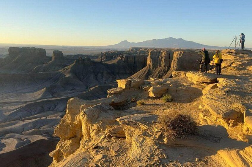 Un paysage accidenté, parsemé de formations rocheuses, avec une chaîne de montagnes qui se profile à l’horizon. 2