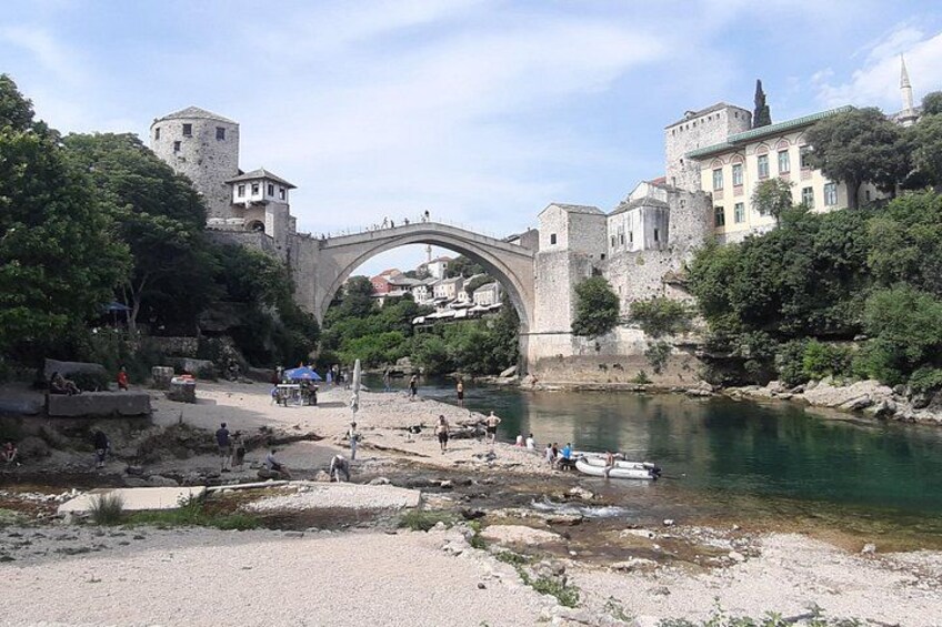 Un pont de pierre, une rivière et des bâtiments historiques. 1