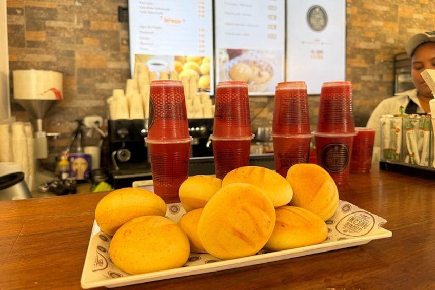A tray of yellow doughnuts and red plastic cups on a wooden table. 3