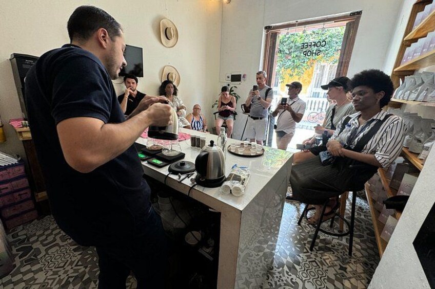 Una persona versa il caffè in una tazza al bancone di un bar. 4