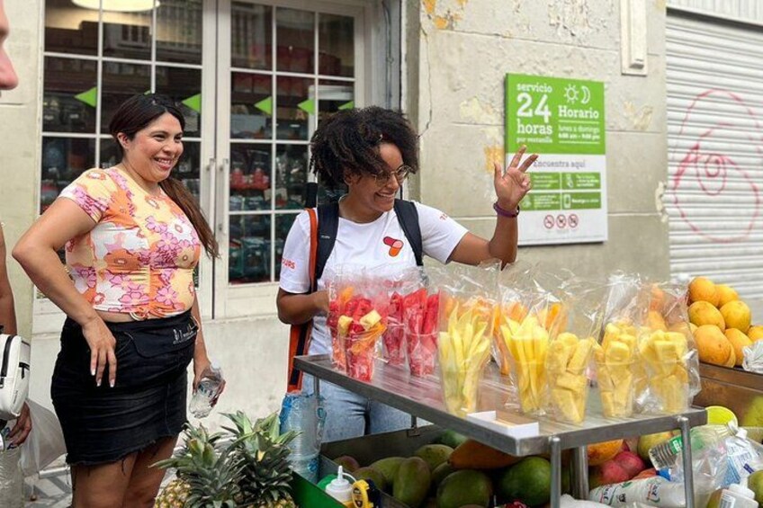 Two women at a fruit stand with a sign indicating 24-hour service. 5