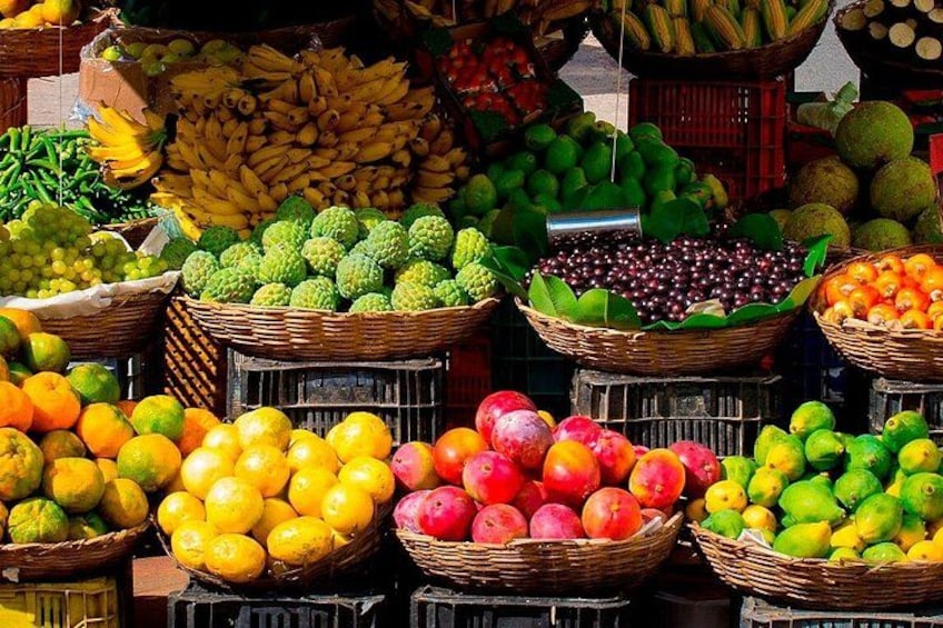 A variety of fruits displayed in baskets at a market stall. 2