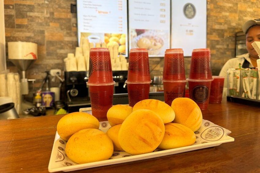 A tray of yellow doughnuts and red plastic cups on a wooden table. 3