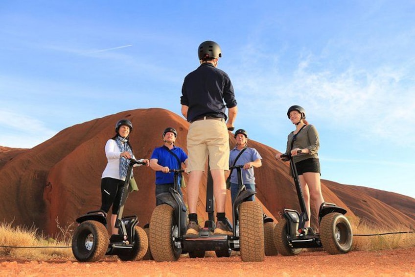 People on Segways in a desert landscape with red rock formations. 1