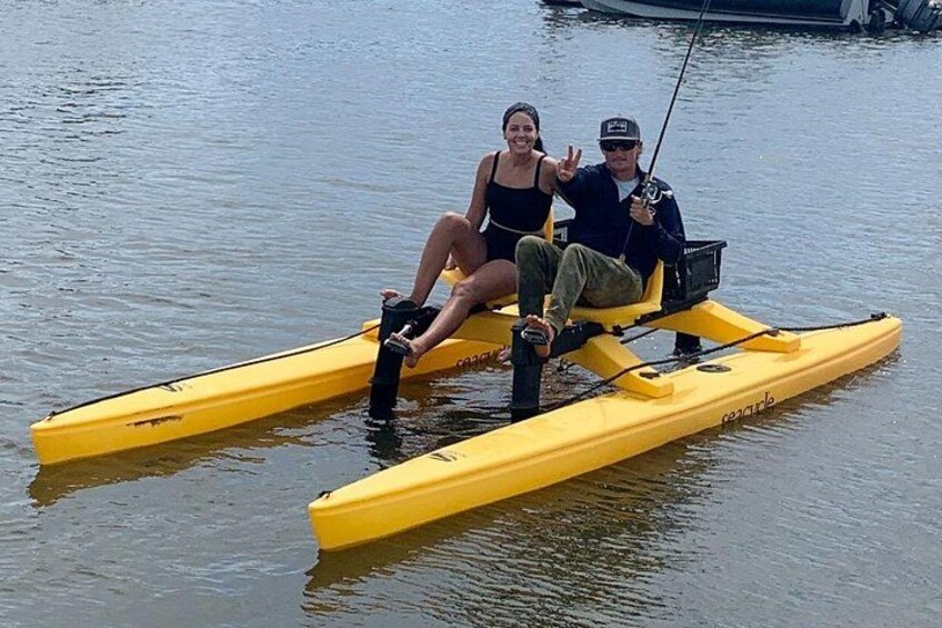 Two people on a yellow kayak in calm water. 4