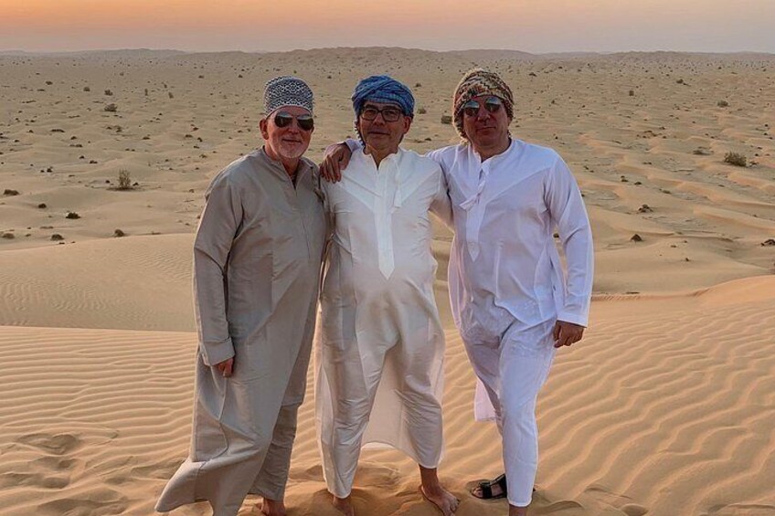 Three people standing on a sand dune in a desert landscape. 2
