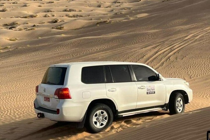 A white SUV on a sandy dune. 4