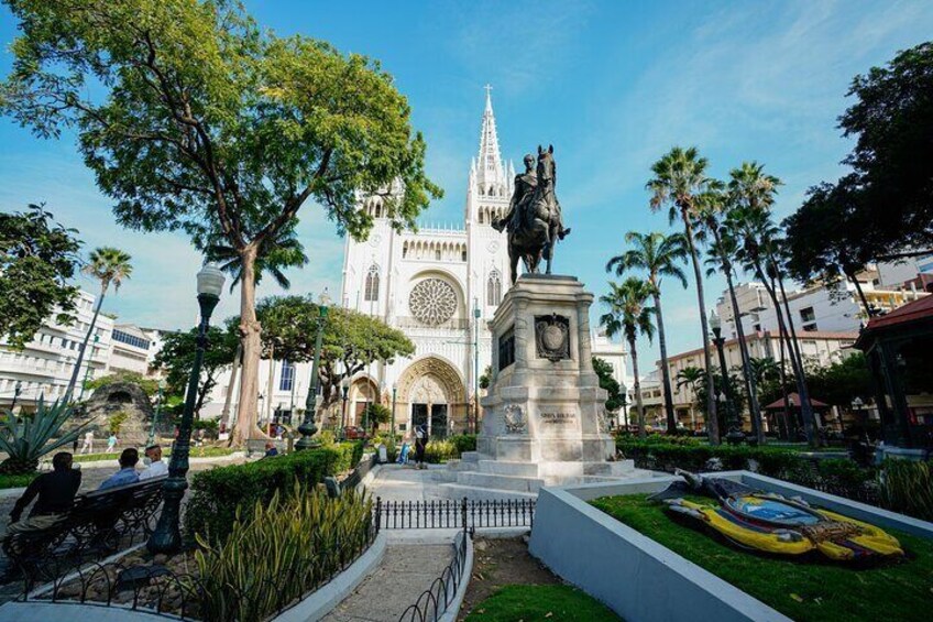 A cathedral with a large circular window and a statue in front. 2