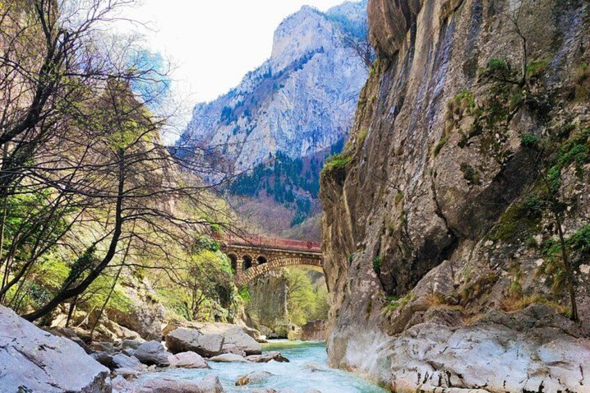 Une rivière qui traverse une région montagneuse, avec un pont et des falaises rocheuses. 3