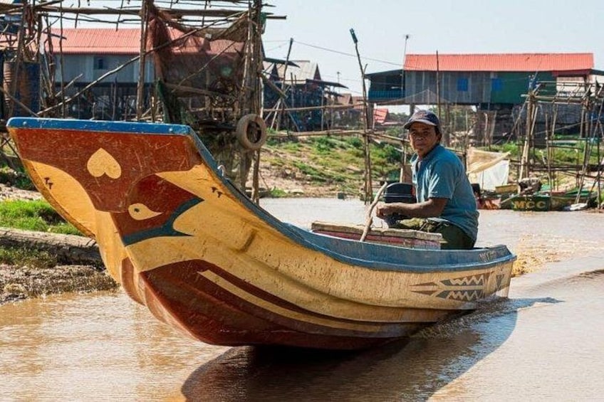 A man in a boat with a heart design, on a riverbank. 2