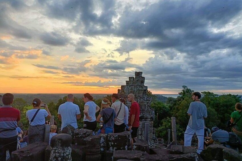 Eine Gruppe von Menschen betrachtet antike Ruinen im Sonnenuntergang. 5