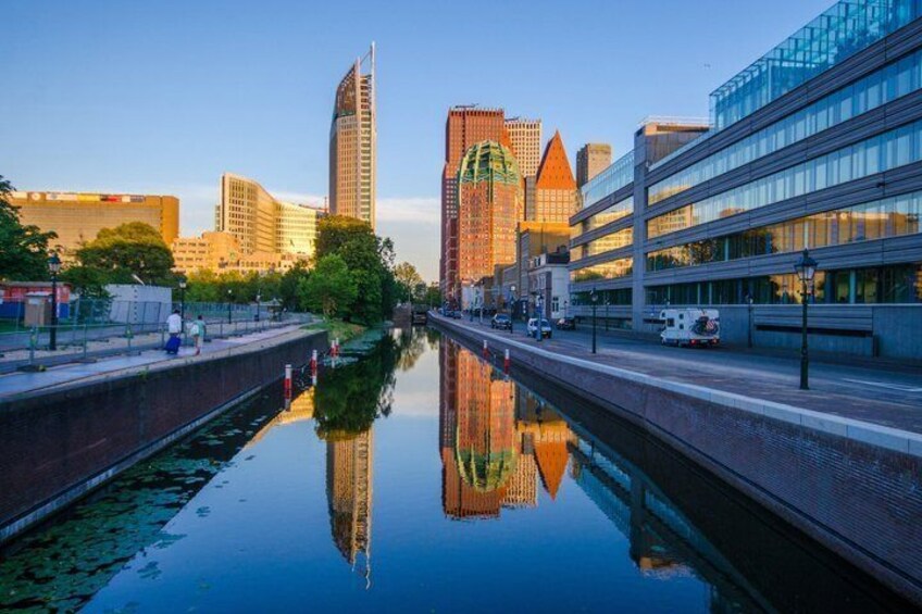 A canal with buildings reflecting on the water, a bridge, and a modern building on the right. 3
