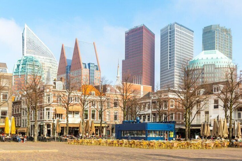 A cityscape with modern skyscrapers, historic buildings, and a café-lined street. 2