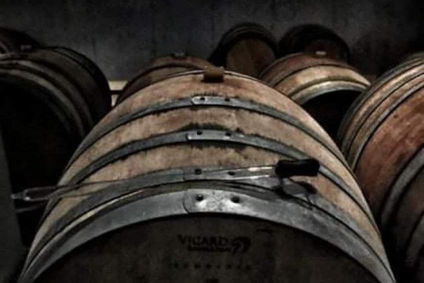 Wooden barrels with metal bands, likely used for aging wine or spirits. 1