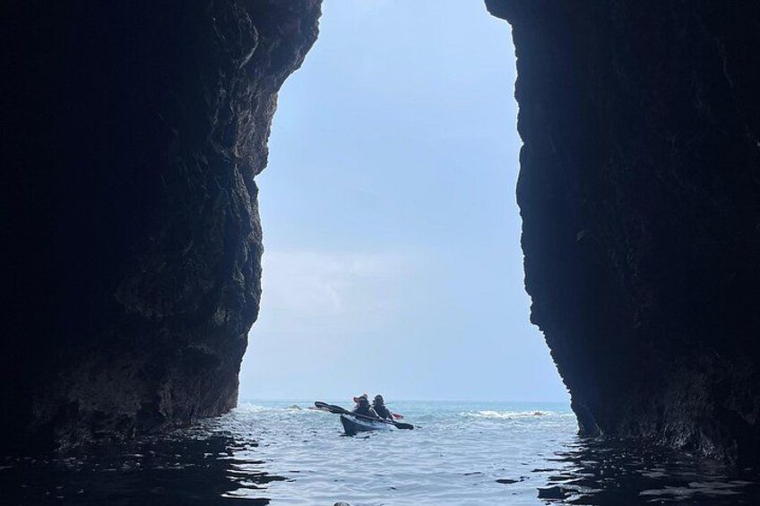 A kayaker in a narrow waterway framed by large rock formations. 5