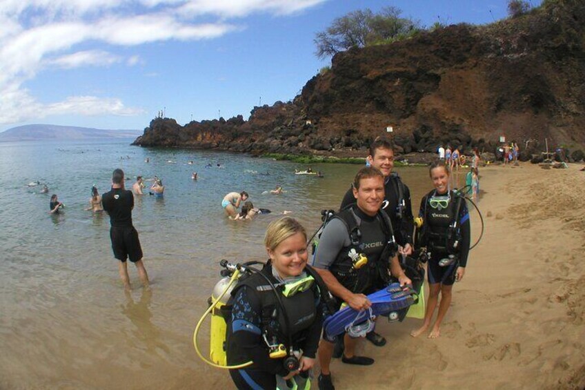 A group of people with scuba gear on a beach. 4