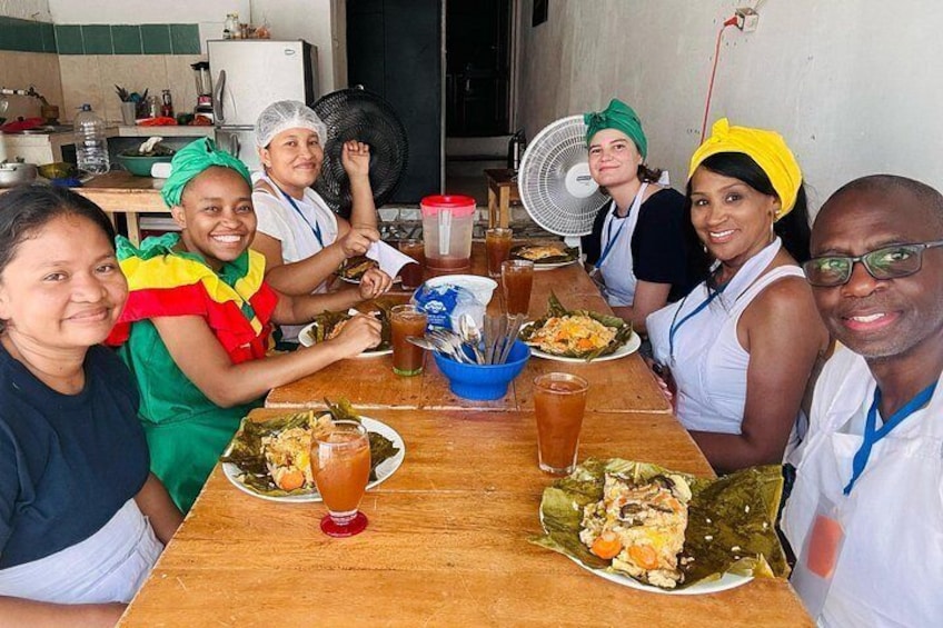 Un grupo de personas sentadas alrededor de una mesa de madera con comida y bebidas. 2