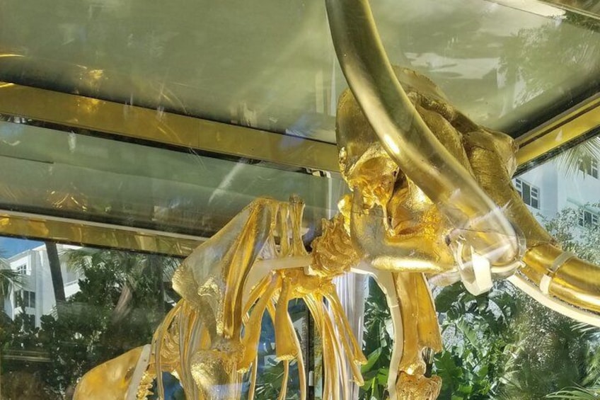 A golden sculpture of a mythical creature with a large head and multiple limbs. 2