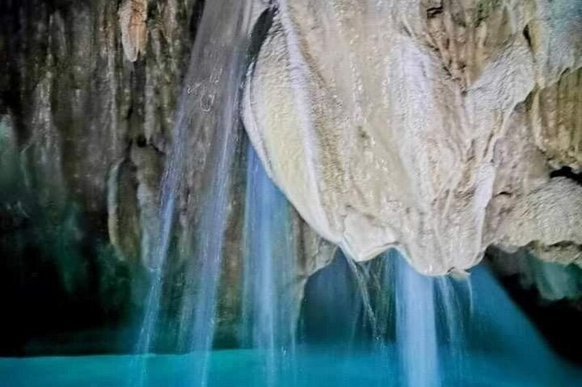 A cave with stalactites and a waterfall. 2