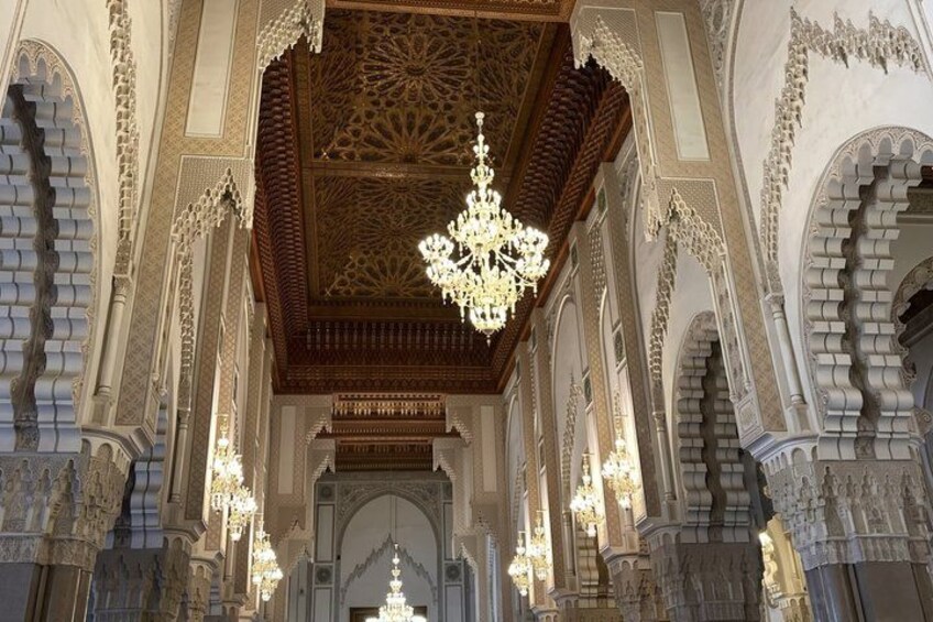 An ornate interior with intricate arches and a large chandelier. 5