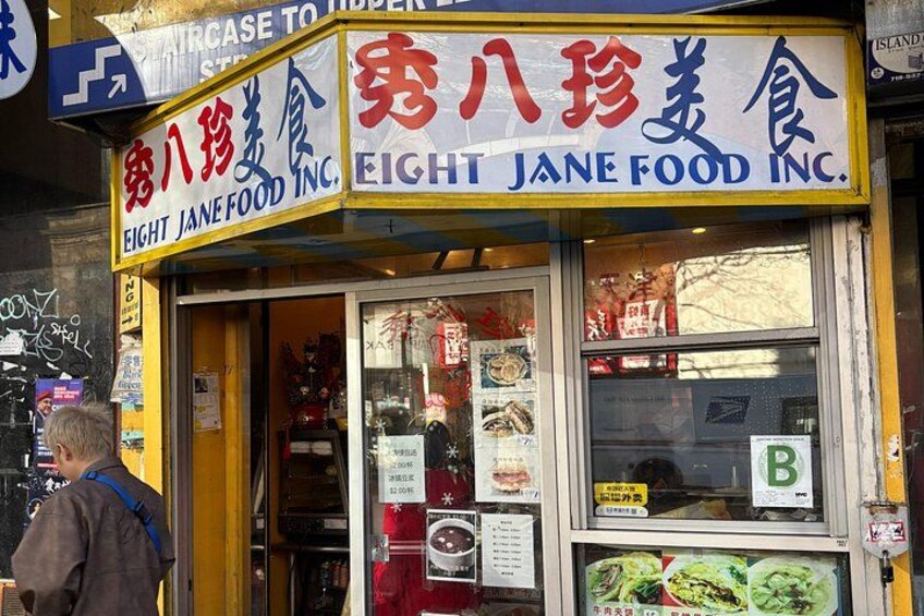 Una vetrina con un cartello che riporta 'Eight Jane Food Inc.' ed espone diversi prodotti alimentari. 2