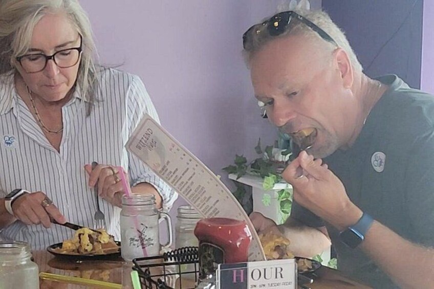Deux personnes sont assises à une table, devant un menu, un bocal avec une paille rose et une tasse. 4