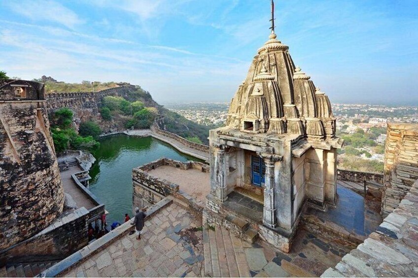 A historical fort with a temple on a hilltop overlooking a river. 2