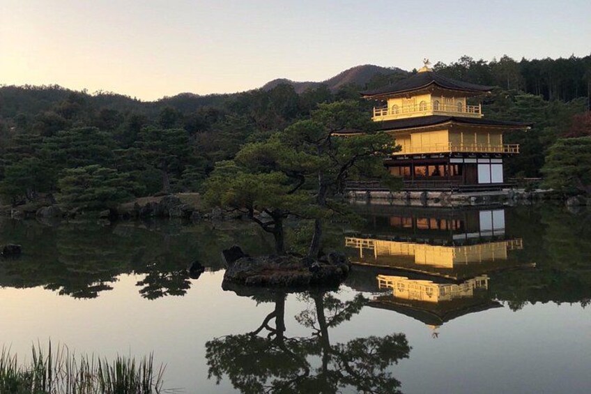 A traditional Japanese building with a reflection in the water, surrounded by trees and hills. 5