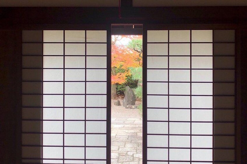 A traditional Japanese shoji screen with a view of a garden. 1