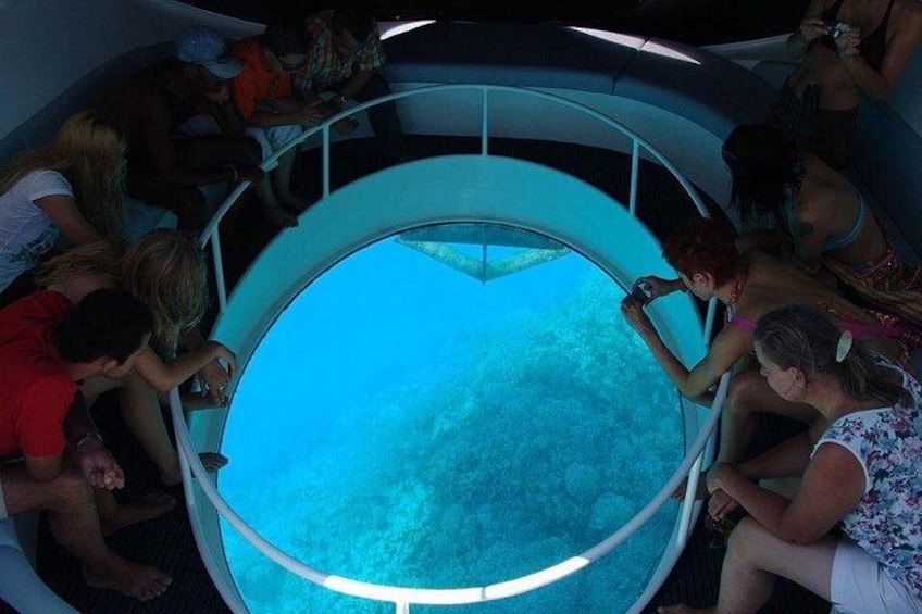 Une plateforme d’observation circulaire où des personnes observent un grand aquarium. 2