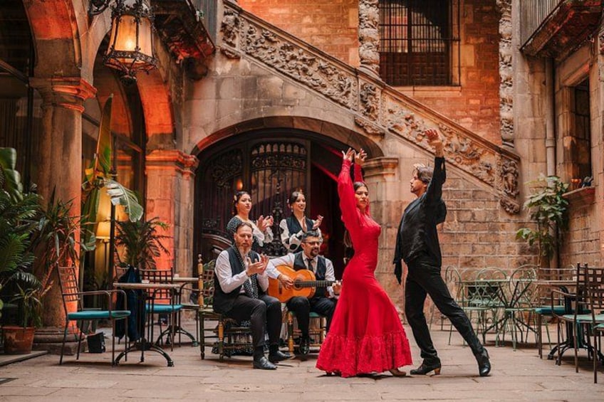 Ett par dansar på en innergård medan en grupp musiker spelar på sina instrument. 1