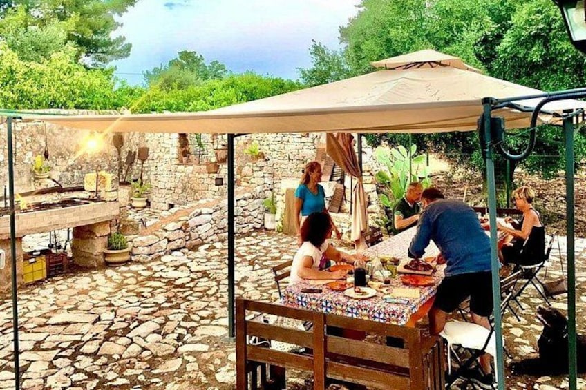 An outdoor dining area with a stone floor, wooden table, and a canopy. 1