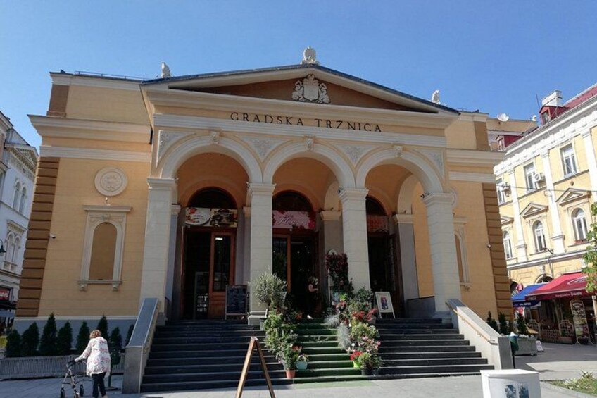 A building with a yellow facade, arched entrance, and steps leading up to it. 2