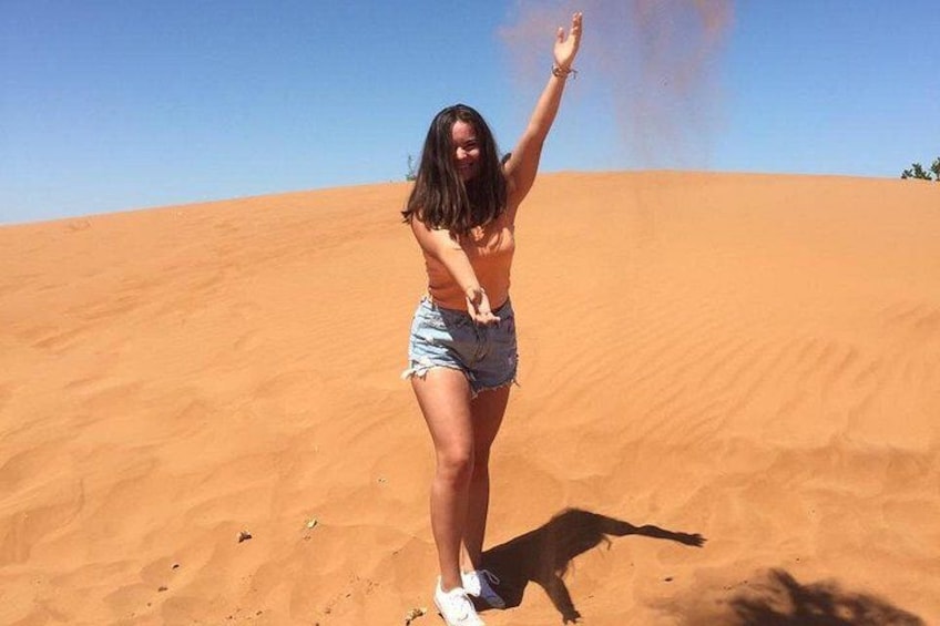 A person standing on a sand dune with a clear sky. 5